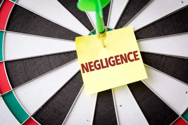 A dartboard with a post-it that says Negligence in a Denver office 
