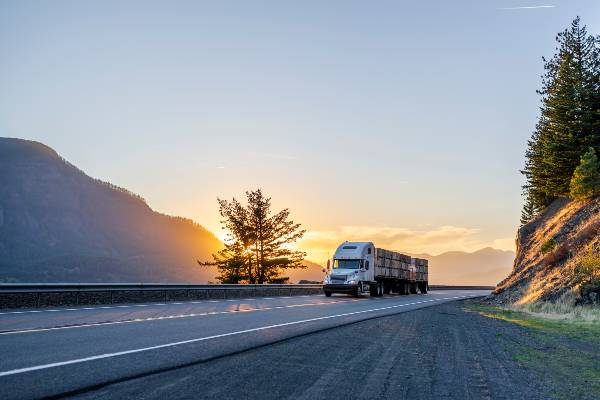 A truck is driving on a COlorado road at sunset