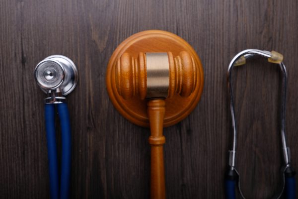 A gavel and a  stethoscope sit on a lawyers desk in Colorado