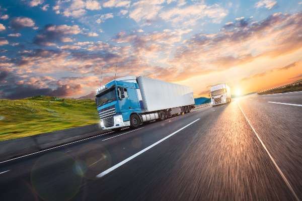 Two large trucks travel through Colorado to get to their destination